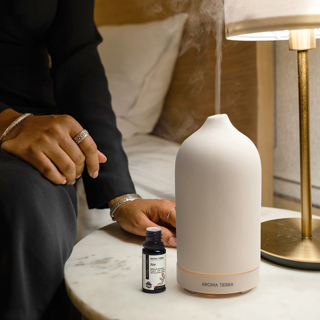 Lady using Joy essential oil blend in diffuser at bedtime for relaxation and good mood