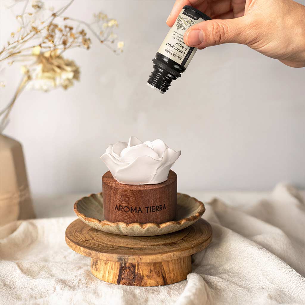 hand adding lemongrass & basil essential oil to cera flora wood diffuser