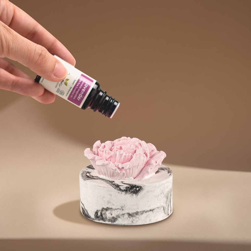 hand adding essential oil to cera flora ceramic non-electric diffuser