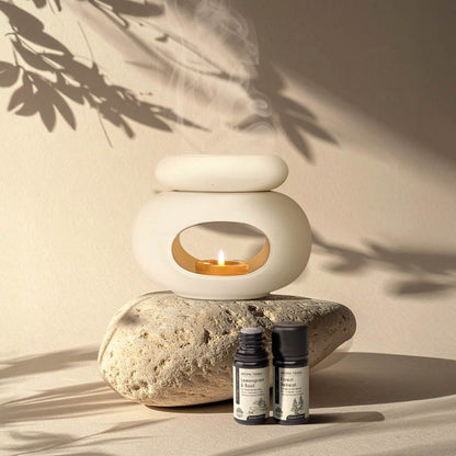 Aroma Tierra Lona ceramic candle burner on natural stone with Lemongrass & Basil and Forest Retreat essential oils