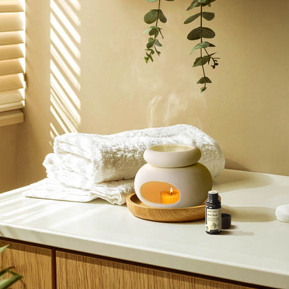 Aroma Tierra Lona ceramic candle burner with Mint Rush essential oil on bathroom counter with eucalyptus and towels